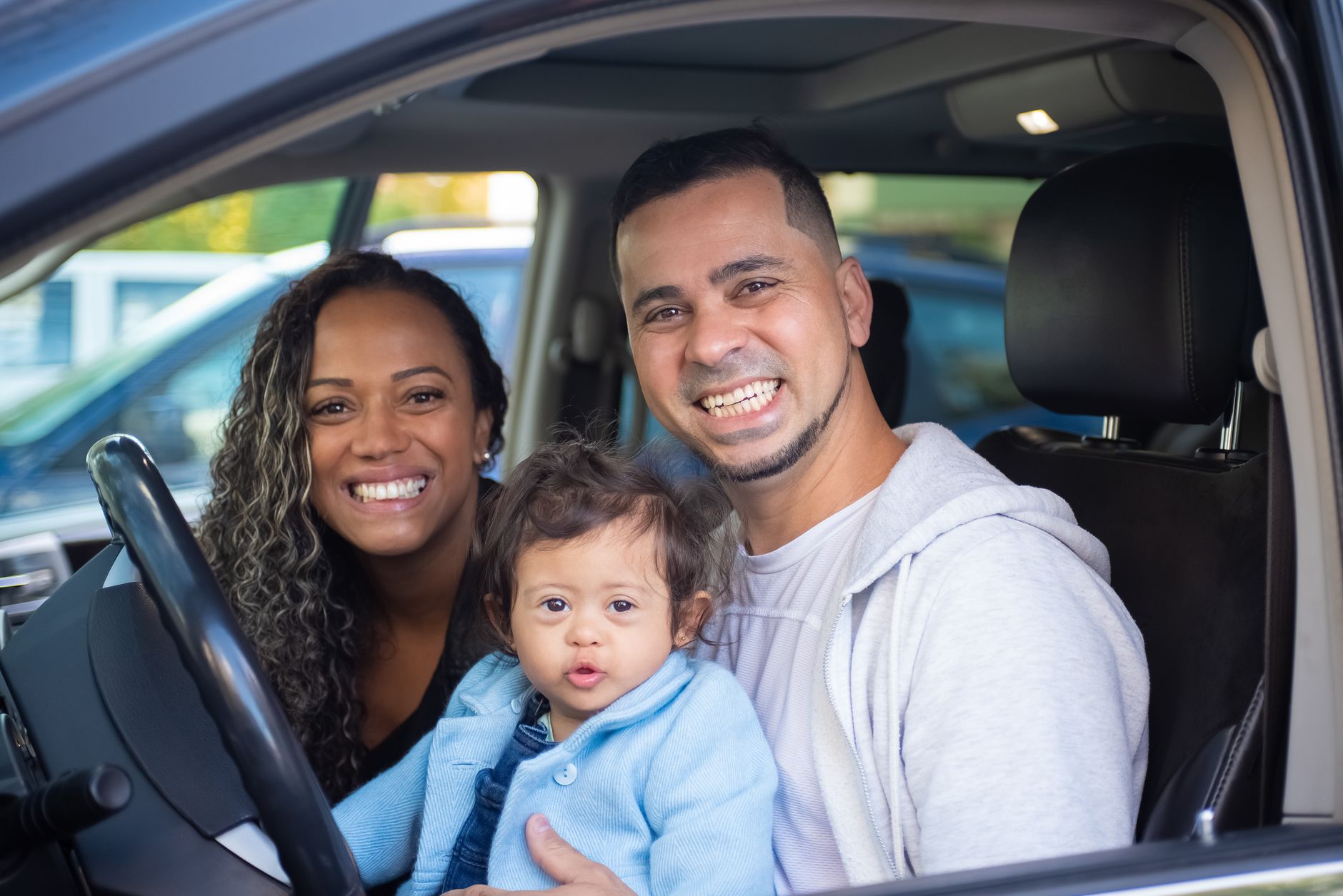 Família sorridente dentro do carro
