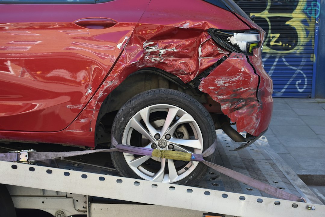 Carro vermelho com a lateral danificada após uma batida